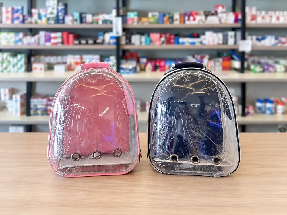 Duas mochilas transparentes de transporte, uma rosa e uma azul